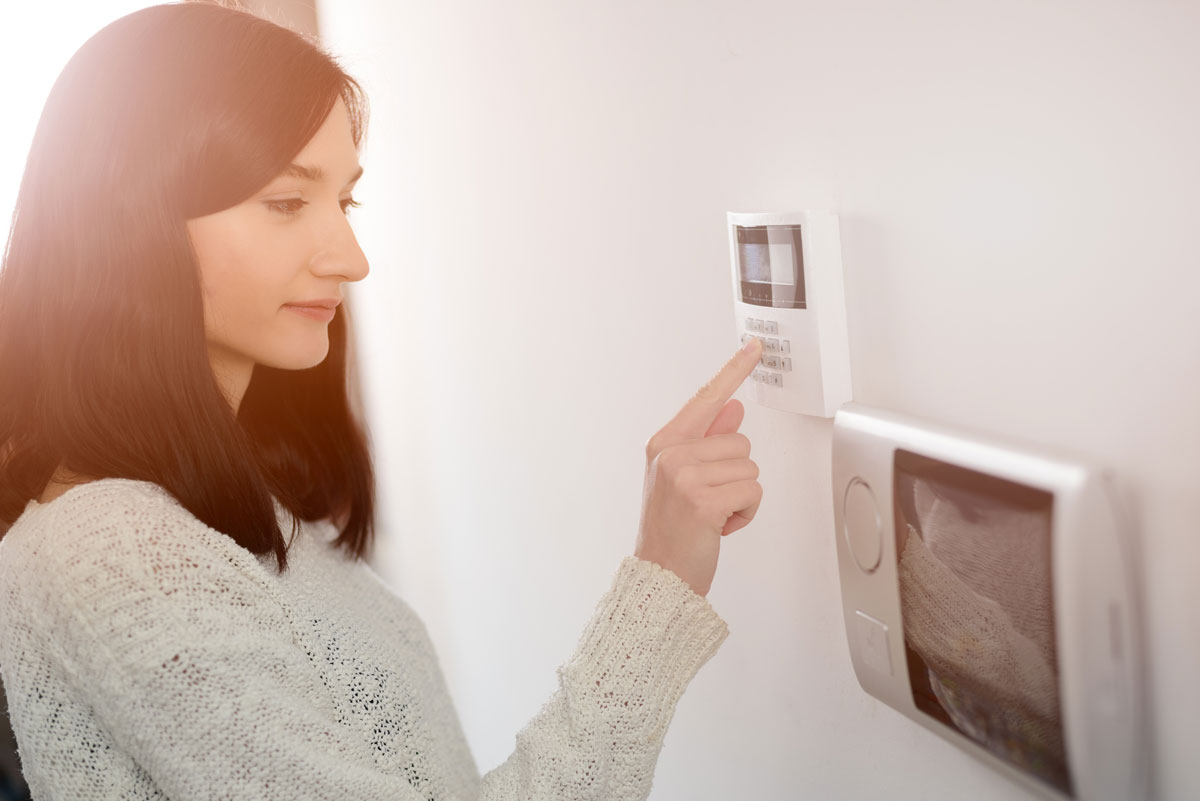 Woman Pressing a Home Alarm System at a Ponte Vedra, FL Home