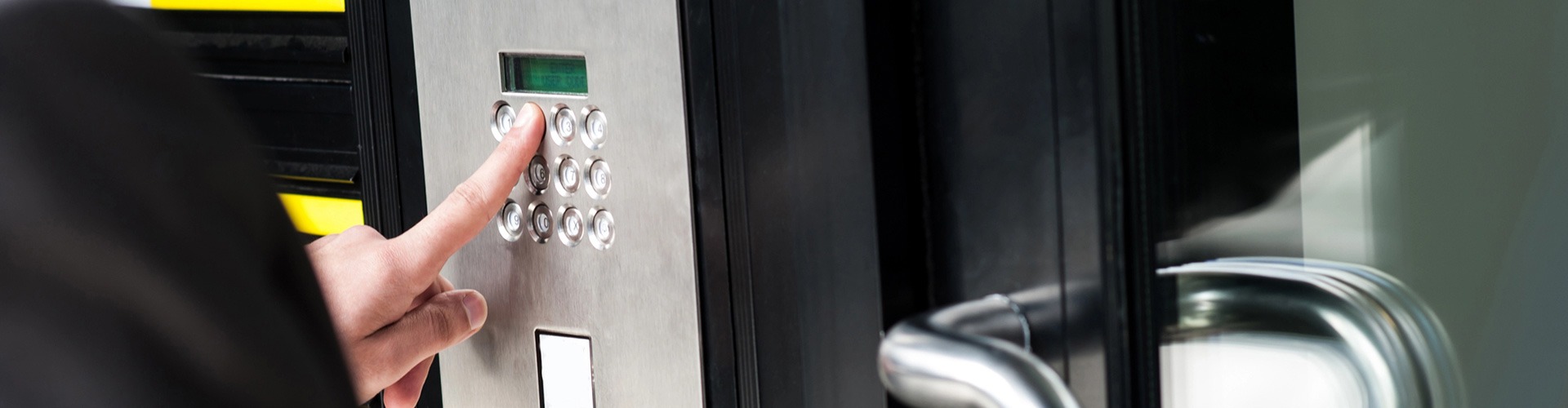 fingers on keypad for Commercial Security Systems